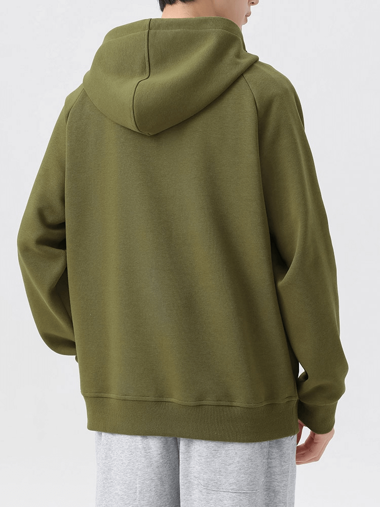 Model wearing green fashion long sleeves half-zip hoodie with pockets, showcasing back view and hooded design for men.